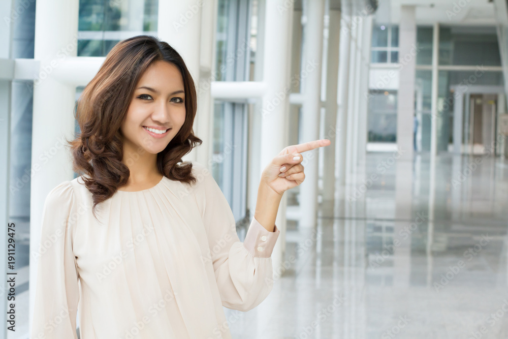 business woman pointing sideway to blank space, office building rental space offer concept business woman pointing sideway to blank space, office building rental space offer concept