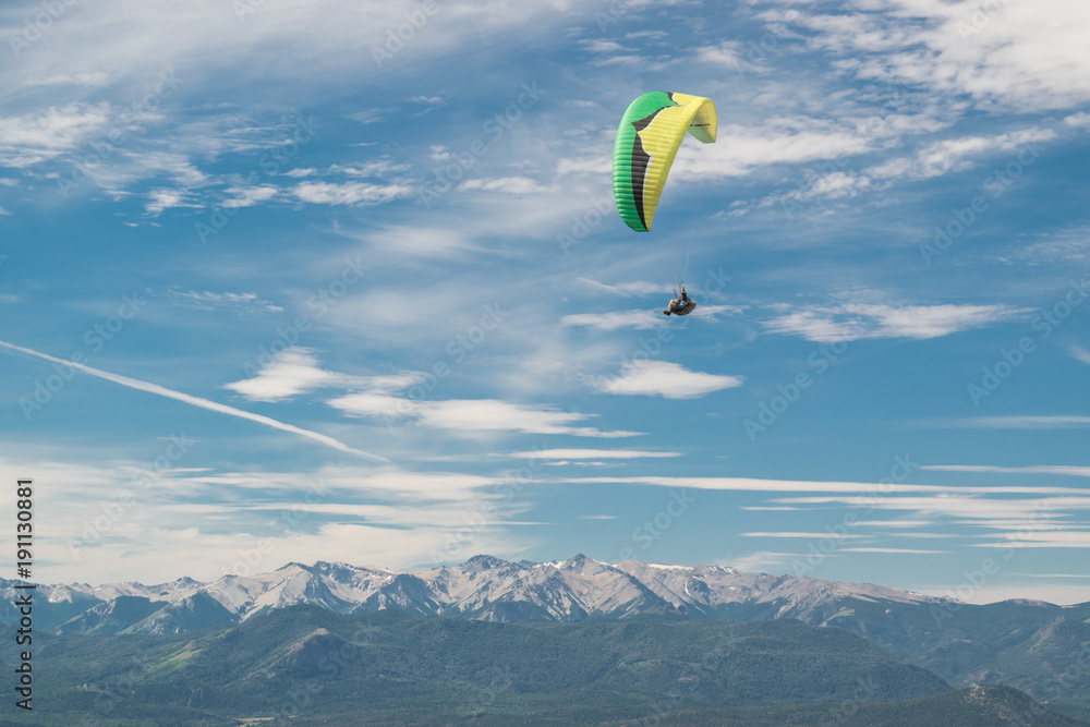 Parapente color verde planeando sobre las montañas nevadas Parapente color verde planeando sobre las montañas nevadas
