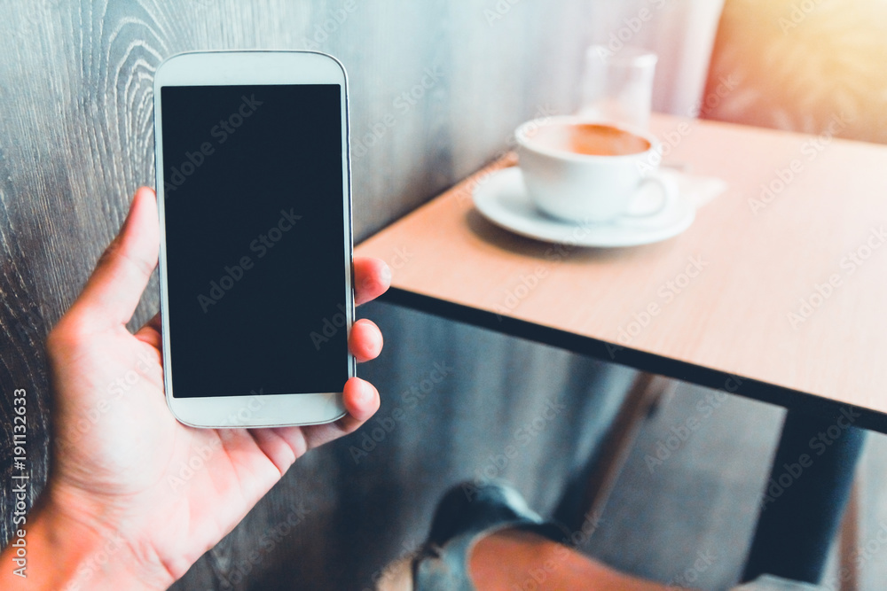 Close up of men  hands holding touching mobile phone with blank copy space for your text message in cafe with light Sunset,Vintage tone.Selective focus