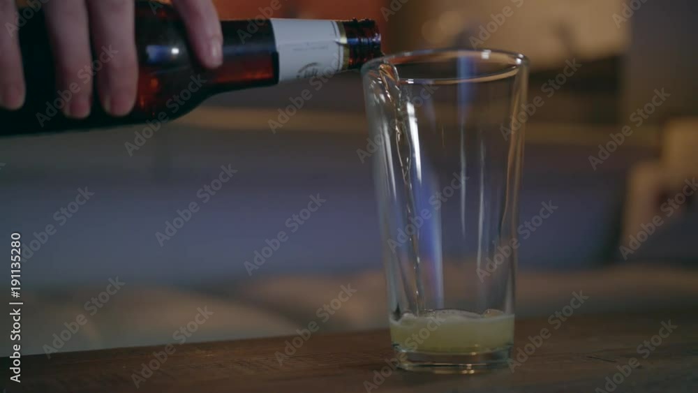 Pouring beer from the bottle into the glass. Pouring beer from the bottle into the glass.