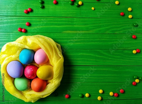 multicolored eggs on wooden green background 