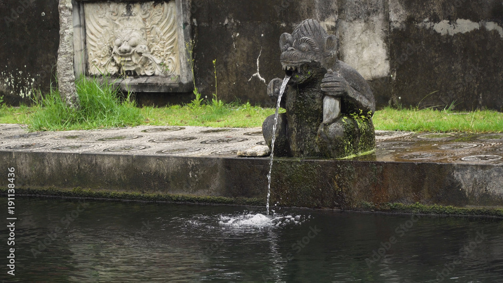 Hindu Balinese Water Palace Tirta Gangga with statues of the gods, fountains in the form of a wild boar on Bali island, Indonesia. Tirta Gangga the former royal water palace is a maze of pools and