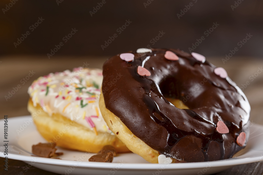 Donuts in a white plate on the table Donuts in a white plate on the table