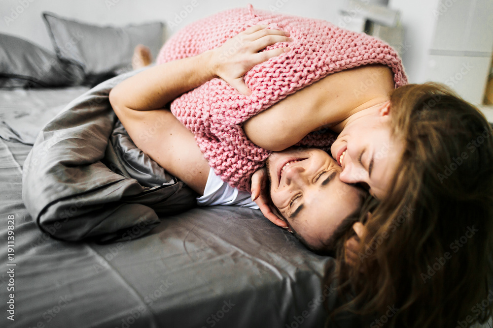 Happy young couple laying on the bed Happy young couple laying on the bed