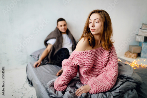 Cute couple sitting on bed. Selective focus on the girlfriend. Artwork
