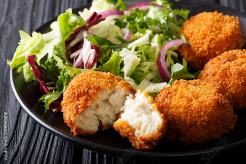 Schilderij op canvas Delicious fish appetizer: cod cake in breading with fresh salad close-up