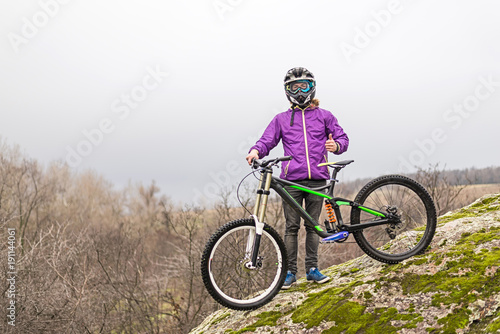 Cyclist holding a mountain bike on top of the free space.