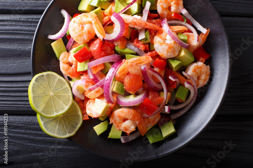 Seviche from marinated shrimp with avocado, pepper, tomatoes and onion close-up. horizontal top view