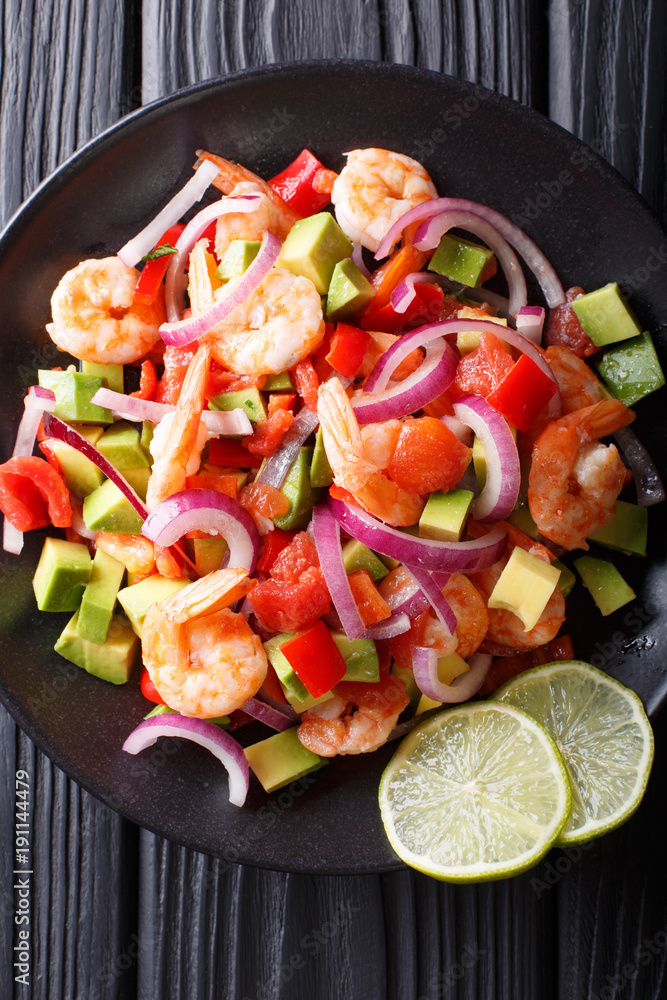 Seviche from marinated shrimp with avocado, pepper, tomatoes and onion close-up. Vertical top view