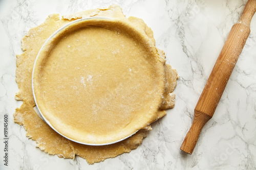 Rolling a pastry for baking a pie and pricking it with fork. Recipe concept