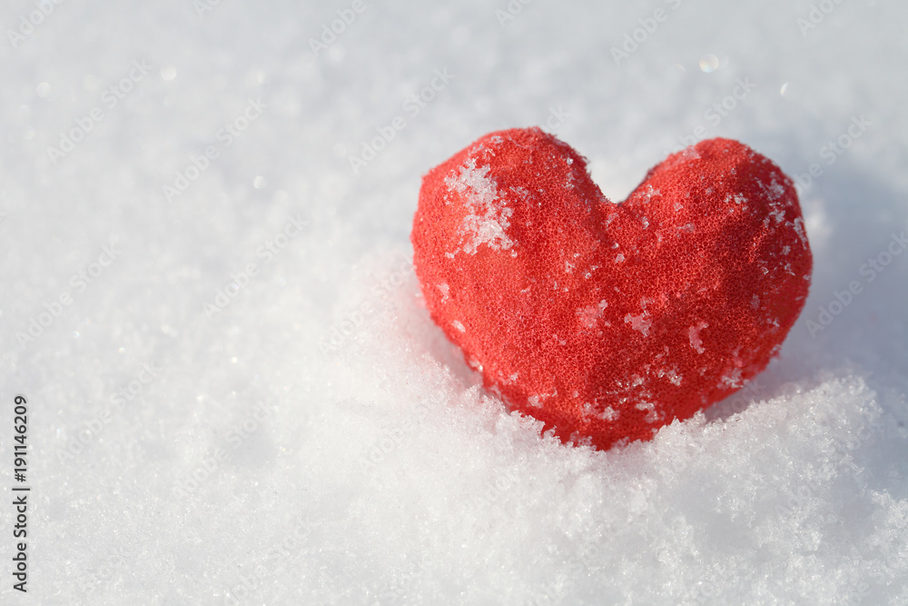 In the snow lies a red heart. A blue background for a greeting card template for Valentine's Day. In the snow lies a red heart. A blue background for a greeting card template for Valentine's Day.