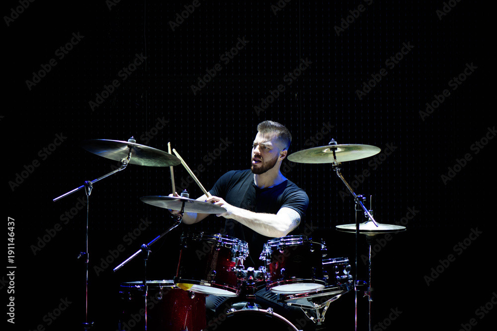 Fototapeta premium Perkusista sylwetka na scenie. Ciemne tło, reflektory dymne