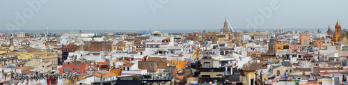 A spring May sky over Spanish Seville old town roofs.