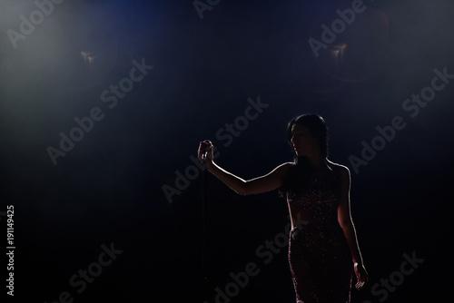 Female singer on the stage holding a microphone photo