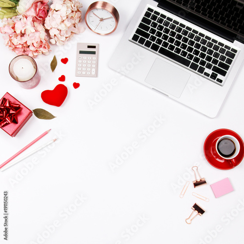 Feminine desk workspace frame with pink beige floral bouquet, red coffee cup, smartphone, accessories and notebook on white background with copy space. Flat lay. Top view. Valentines day background.