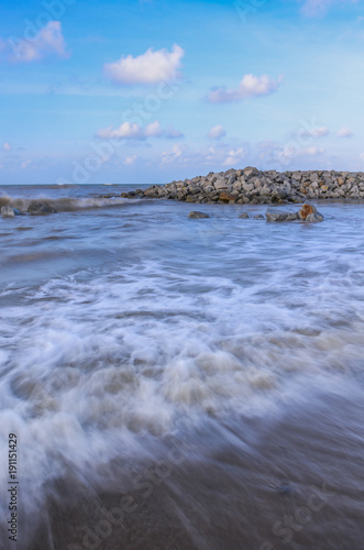 Sea waves lash line impact rock on the beach