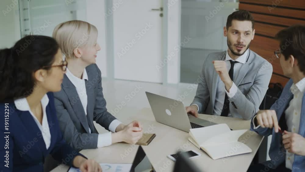 Execuctive manager discussing business plan with colleagues sitting at the table in office meeting room Execuctive manager discussing business plan with colleagues sitting at the table in office meeting room