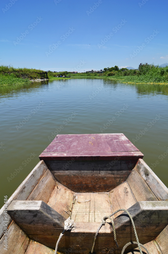 Rowing boat boat cruising along a calm blue river