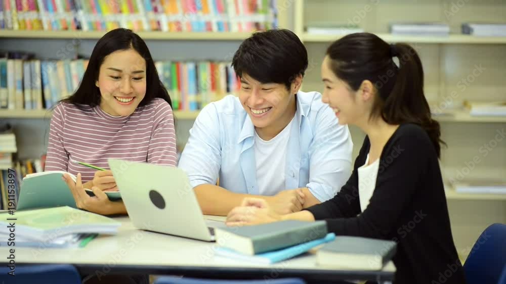 Young students study hard in library. Happy Asian female and male university students doing study research in library with books on desk, notebook. For back to school education diversity concept. Young students study hard in library. Happy Asian female and male university students doing study research in library with books on desk, notebook. For back to school education diversity concept.
