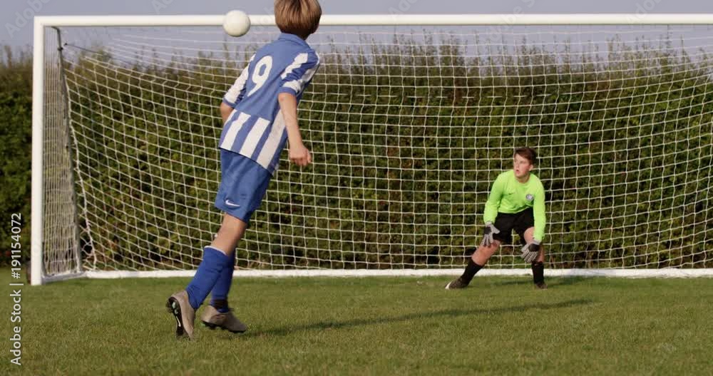 A young boy scores a goal during a penalty shoot out. Shot in slow motion on RED Epic. A young boy scores a goal during a penalty shoot out. Shot in slow motion on RED Epic.