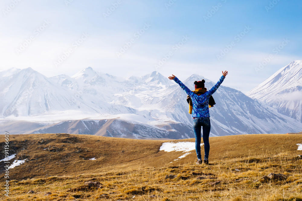woman tourist in a warm hat against the background of high mountains woman tourist in a warm hat against the background of high mountains
