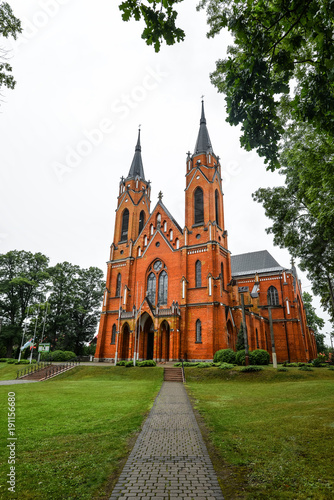 Rajgrod, Poland - August 22, 2017: Ancient church made from red briks and peaceful church park in little poland town Rajgrod, Poland.