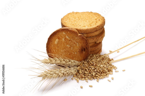 Rusks with integral wholewheat flour, bread slices, ears of wheat and grains isolated on white background