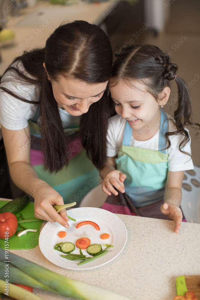 happy family mother and kid girl are preparing healthy food, they improvise together in the kitchen happy family mother and kid girl are preparing healthy food, they improvise together in the kitchen
