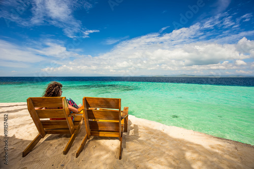 Beach chairs, clear water and beautiful view on tropical island,