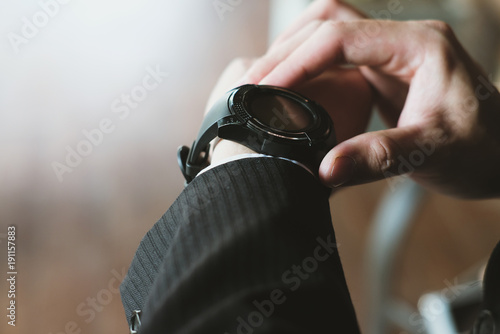 businessman look at watch at workplace. startup man check time on wristwatch. young male entrepreneur late for work