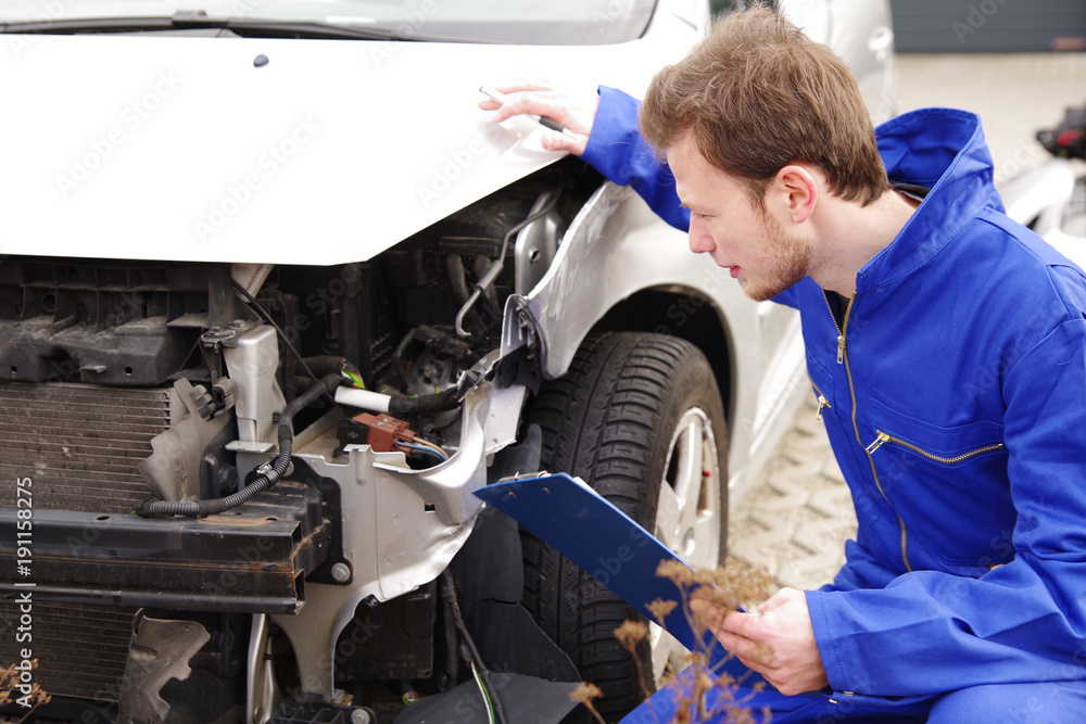 Gutachter inspiziert ein Auto mit Unfallschaden Gutachter inspiziert ein Auto mit Unfallschaden