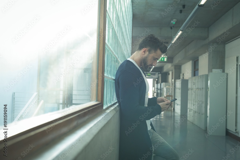 Male executive using mobile phone in corridor Male executive using mobile phone in corridor