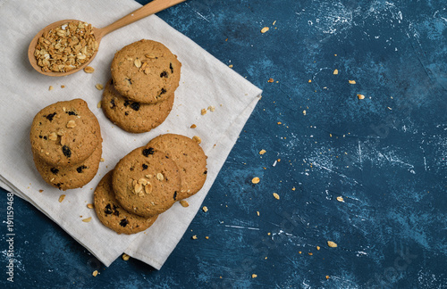 Delicious oatmeal cookies with raisins on concrete blue table background. Sweet pastry.