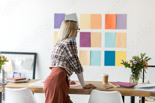 rear view of fashion magazine editor working in modern office with color palette on wall