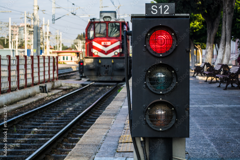traffic light shows red signal on railway; railway station and the