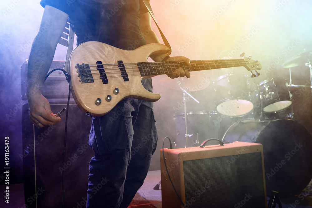 Obraz premium The bass guitarist connects the guitar.