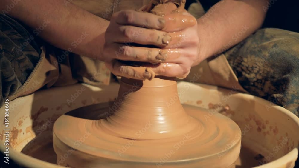 A close view on potters hands throwing a vase. A close view on potters hands throwing a vase.