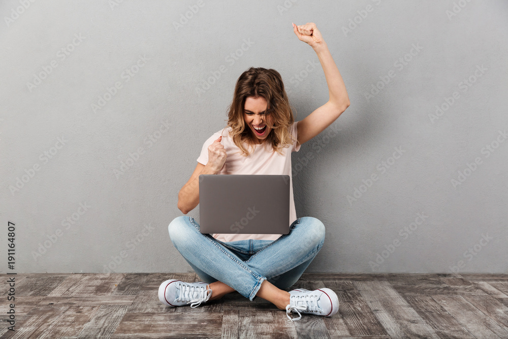 Pleased screaming woman in t-shirt sitting on the floor Pleased screaming woman in t-shirt sitting on the floor