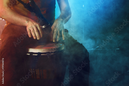 The musician plays the bongo on stage. photo