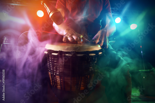 The musician plays the bongo on stage. photo