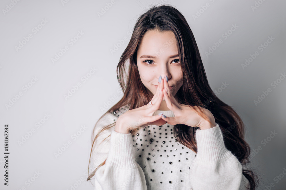 A beautiful woman looks cunning at the camera with a snide smile. Expressive facial features, emotions. A beautiful woman looks cunning at the camera with a snide smile. Expressive facial features, emotions.