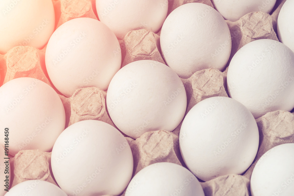 White chicken eggs in a cardboard box, background, texture. Toned White chicken eggs in a cardboard box, background, texture. Toned