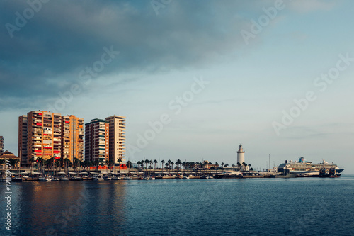 city on the sea. City Waterfront with buildings, lighthouse and ship. Porto of Malaga, Spain. © Visual Intermezzo
