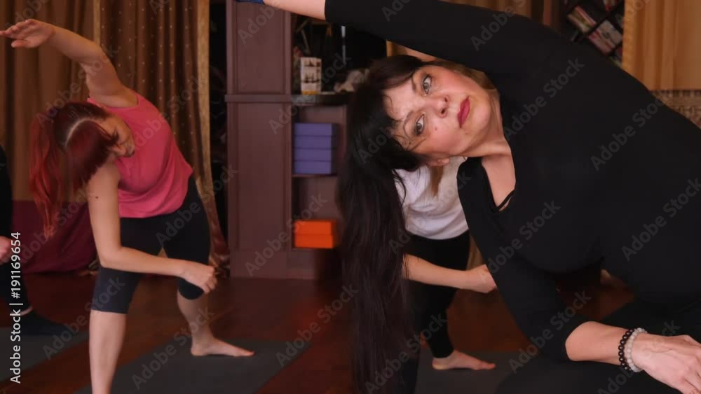 Yoga class of different age people exercising healthy lifestyle in fitness studio yoga with instructor. Slow motion Yoga class of different age people exercising healthy lifestyle in fitness studio yoga with instructor. Slow motion