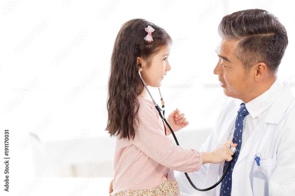 Little girl examining doctor with the stethoscope Little girl examining doctor with the stethoscope