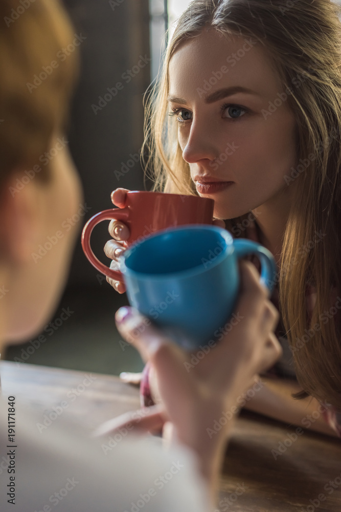 close-up shot of young women drinking coffee together close-up shot of young women drinking coffee together