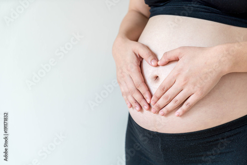Belly of pregnant woman with hands