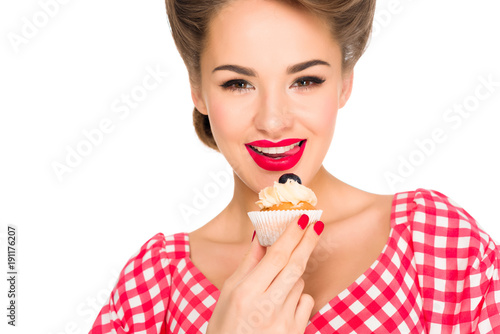 portrait of beautiful woman in pin up clothing with cupcake isolated on white