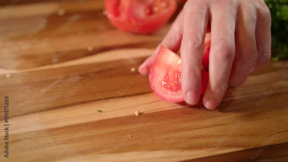 The chef cuts fresh and tasty tomatoe for cooking. Close up view. The chef cuts fresh and tasty tomatoe for cooking. Close up view.