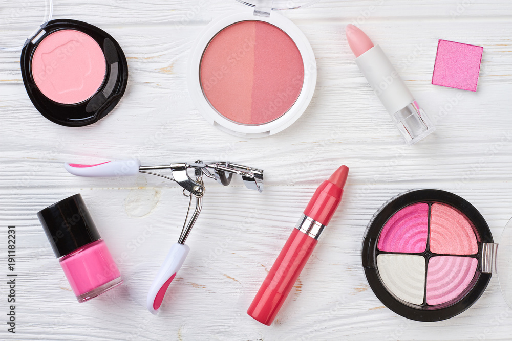 Set of decorative cosmetics, wooden background. Eyelashes curler and pencil lipstick. Make up artist equipment. Set of decorative cosmetics, wooden background. Eyelashes curler and pencil lipstick. Make up artist equipment.